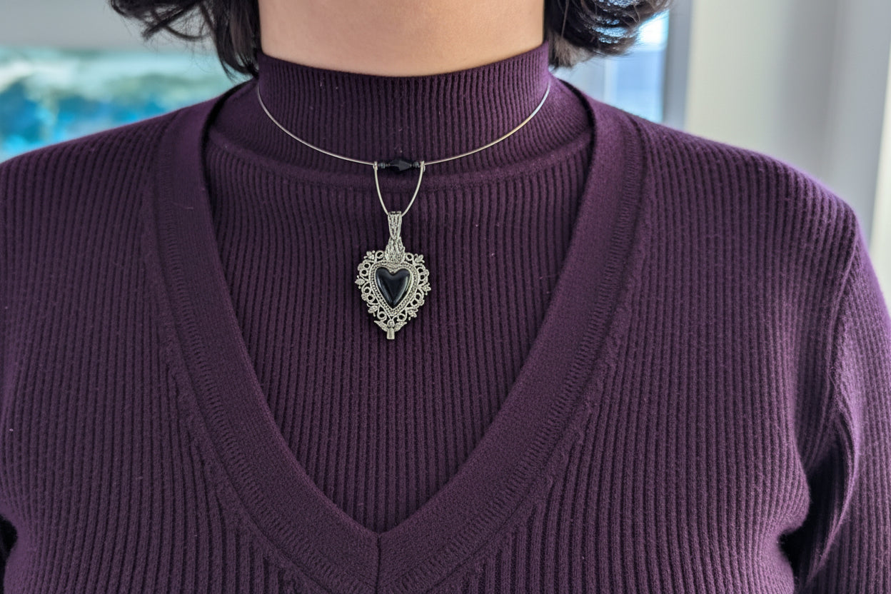 This elegant memory wire choker combines timeless style with modern sophistication. Featuring a striking black stainless steel heart pendant accented with lustrous black beads, it adjusts perfectly to fit neck sizes 4 to 4.5 inches. The durable .025" wire construction ensures lasting wear without losing its shape, while the lightweight design at just 0.28 oz makes it comfortable for all-day elegance. Whether layered with other pieces or worn solo, this versatile choker adds an instant touch of charm to any 