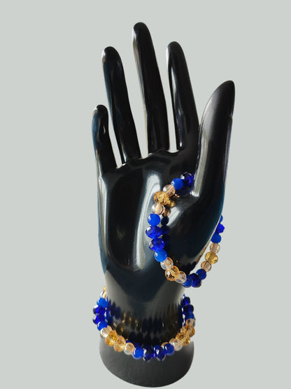 Add a touch of elegance to any outfit with our Bracelet - Elastic 6mm & 8 mm blue & gold glass beads. The elastic design ensures a comfortable fit for all wrist sizes. At a weight of just 0.38 oz, it is lightweight and easy to wear all day long. Elevate your style with this stunning bracelet.

Bracelet - Elastic 6mm & 8 mm blue & gold glass beads