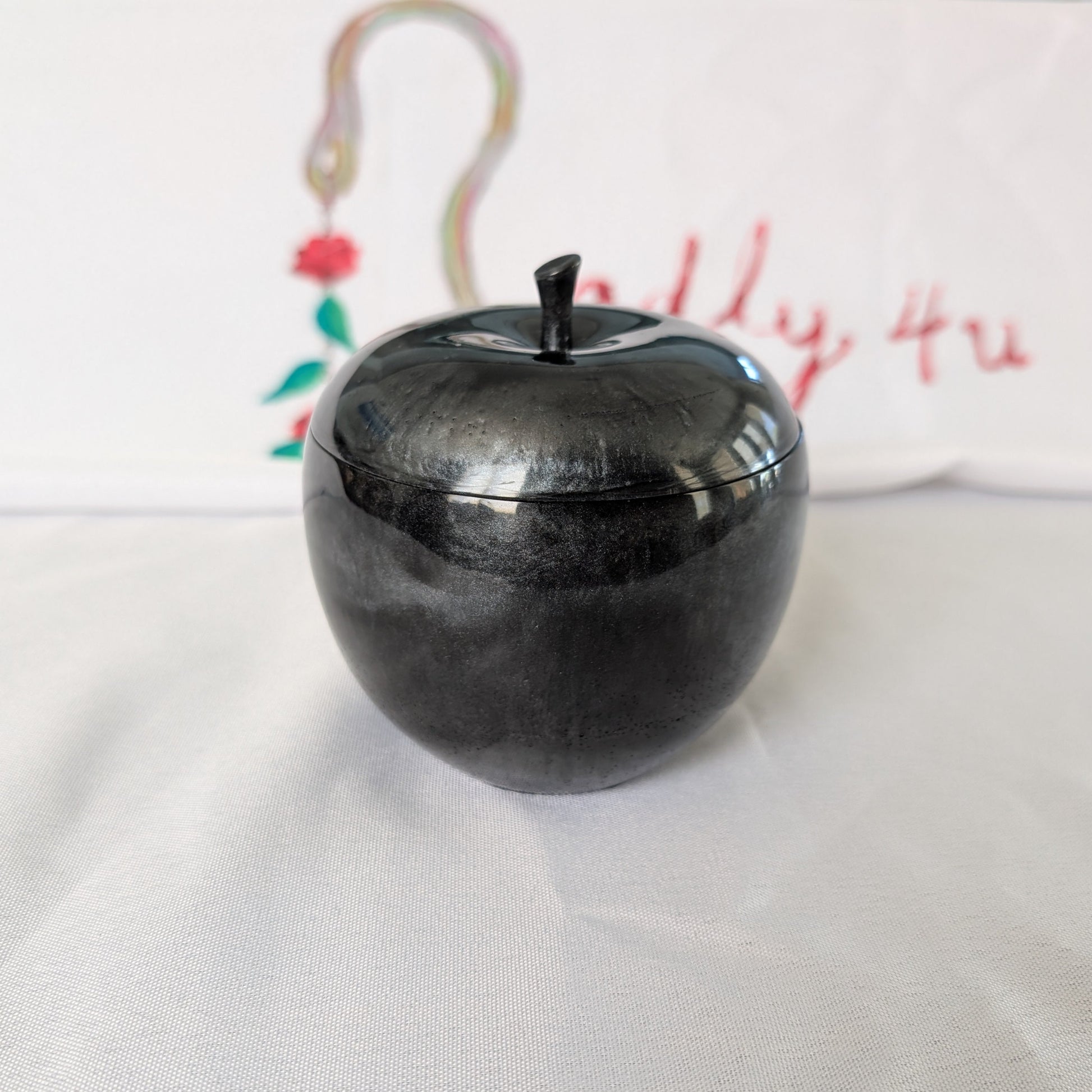 hand crafted with epoxy resin..

Epoxy resin is typically smooth, rigid, and non-porous, similar to a hard plastic or glass.

Knickknack - Resin apple trinket with lid