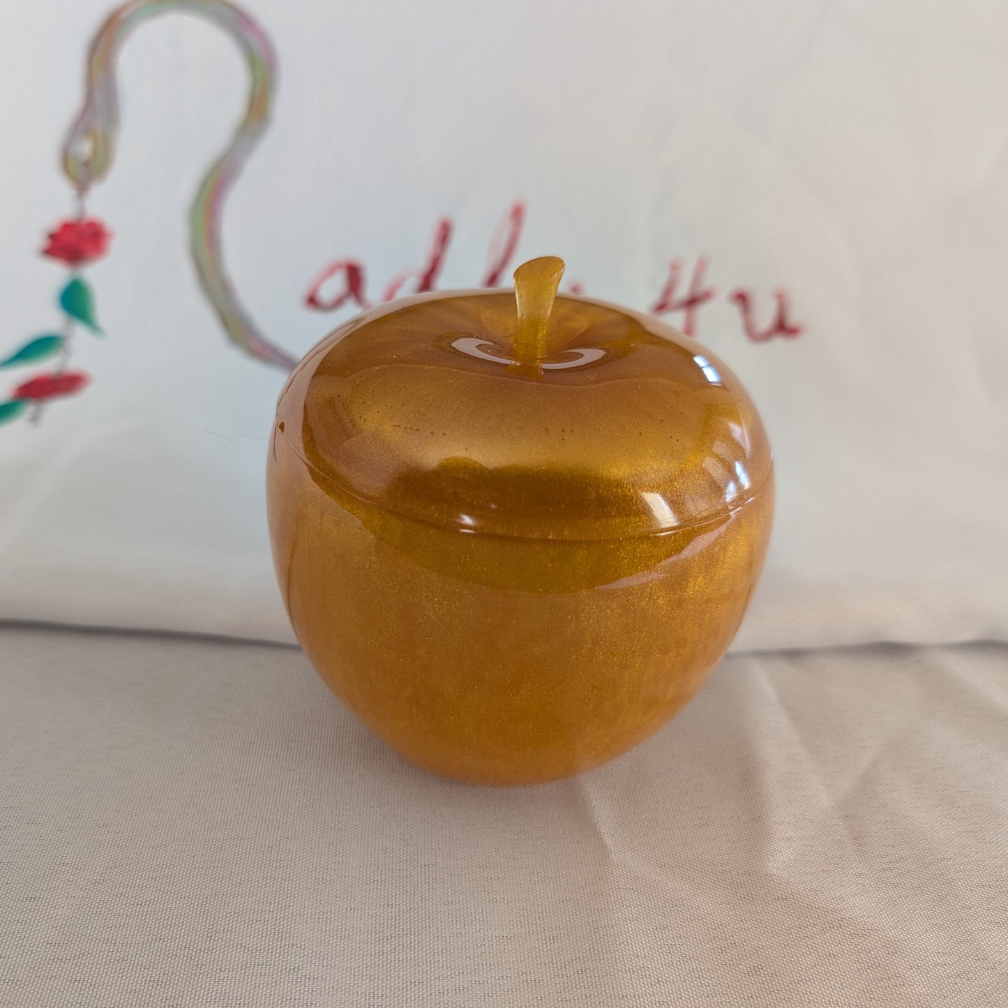 hand crafted with epoxy resin..

Epoxy resin is typically smooth, rigid, and non-porous, similar to a hard plastic or glass.

Knickknack - Resin apple trinket with lid