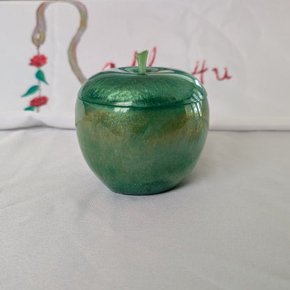hand crafted with epoxy resin..

Epoxy resin is typically smooth, rigid, and non-porous, similar to a hard plastic or glass.

Knickknack - Resin apple trinket with lid