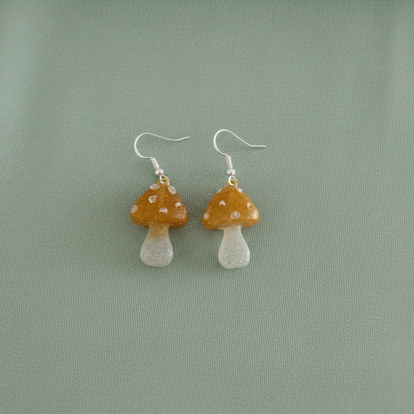 Mushroom-shaped earrings on a green background