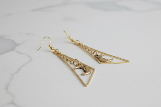 Add a touch of celestial sparkle to your look with these gorgeous golden earrings! Crafted with an intricate geometric triangle and featuring a delicate moon, these spring hook earrings provide an elegant finishing touch for any ensemble.