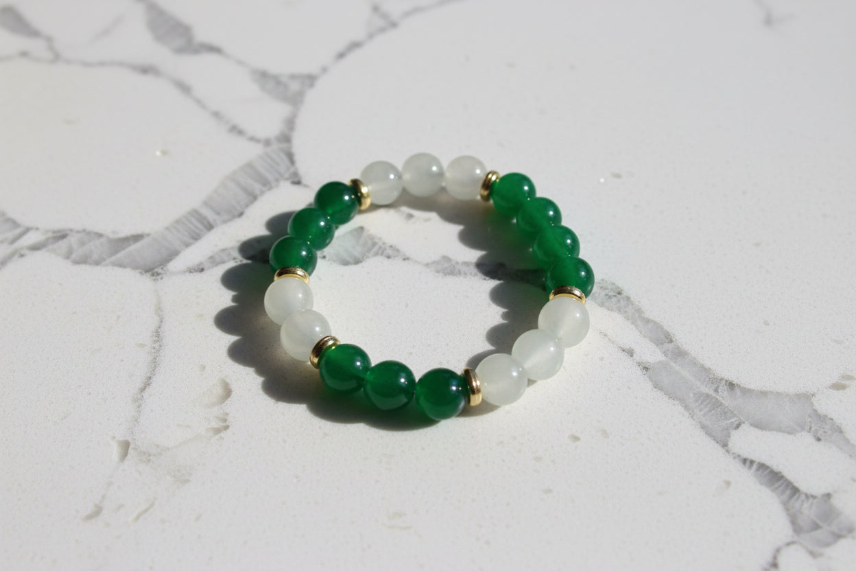 Elevate your style with our stunning elastic bracelet, featuring green and white 8mm glass beads and luxurious gold metal spacer beads. Effortlessly add a touch of elegance to any outfit while enjoying the comfort and convenience of an elastic band. Perfect for any occasion, this bracelet is a must-have for any fashion-forward individual!