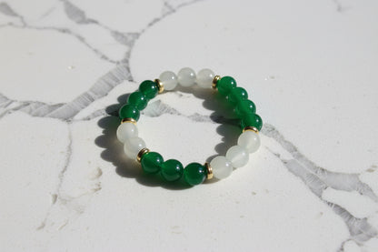 Elevate your style with our stunning elastic bracelet, featuring green and white 8mm glass beads and luxurious gold metal spacer beads. Effortlessly add a touch of elegance to any outfit while enjoying the comfort and convenience of an elastic band. Perfect for any occasion, this bracelet is a must-have for any fashion-forward individual!