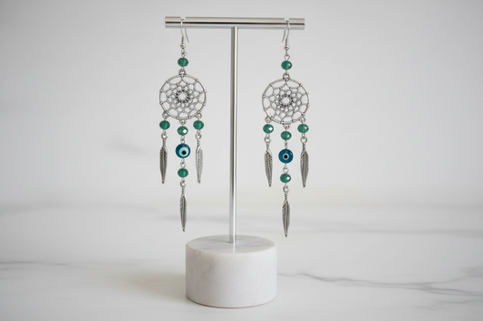 Embrace your inner free-spirit with our beautiful dream catcher earrings! Adorned with a protective evil eye and delicate beads, these earrings will bring positive energy and ward off negative vibes. Perfect for adding a touch of bohemian charm to any outfit. Get yours today and catch your dreams!