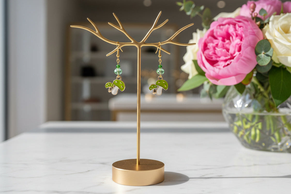 Enchanting mushroom earrings featuring delicate crystal beads nestled on lustrous gold plated hooks. Each earring measures approximately 2 inches, striking the perfect balance between statement-making and wearable elegance. At just 0.15 oz per pair, these lightweight beauties won't weigh you down, making them ideal for all-day wear. The shimmering gold plating catches the light beautifully, while the crystal accents add a touch of sparkle and sophistication. 