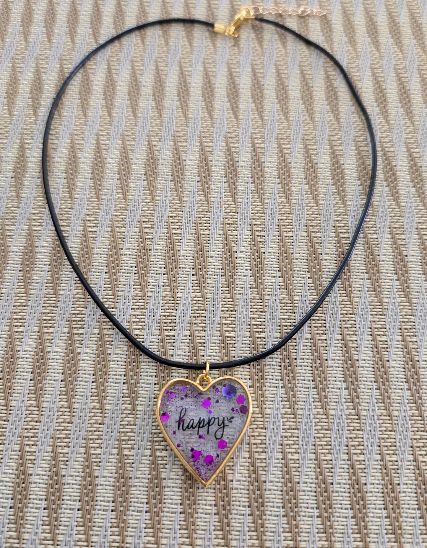 Fall in love with this 18 inch resin and glitter gold heart pendant necklace! The vibrant charm hangs beautifully on a black 2mm leather cord, adding a touch of happiness to any outfit. With a weight of only 0.2 oz, you'll hardly feel it's there. Don't miss out on this unique and stylish piece!