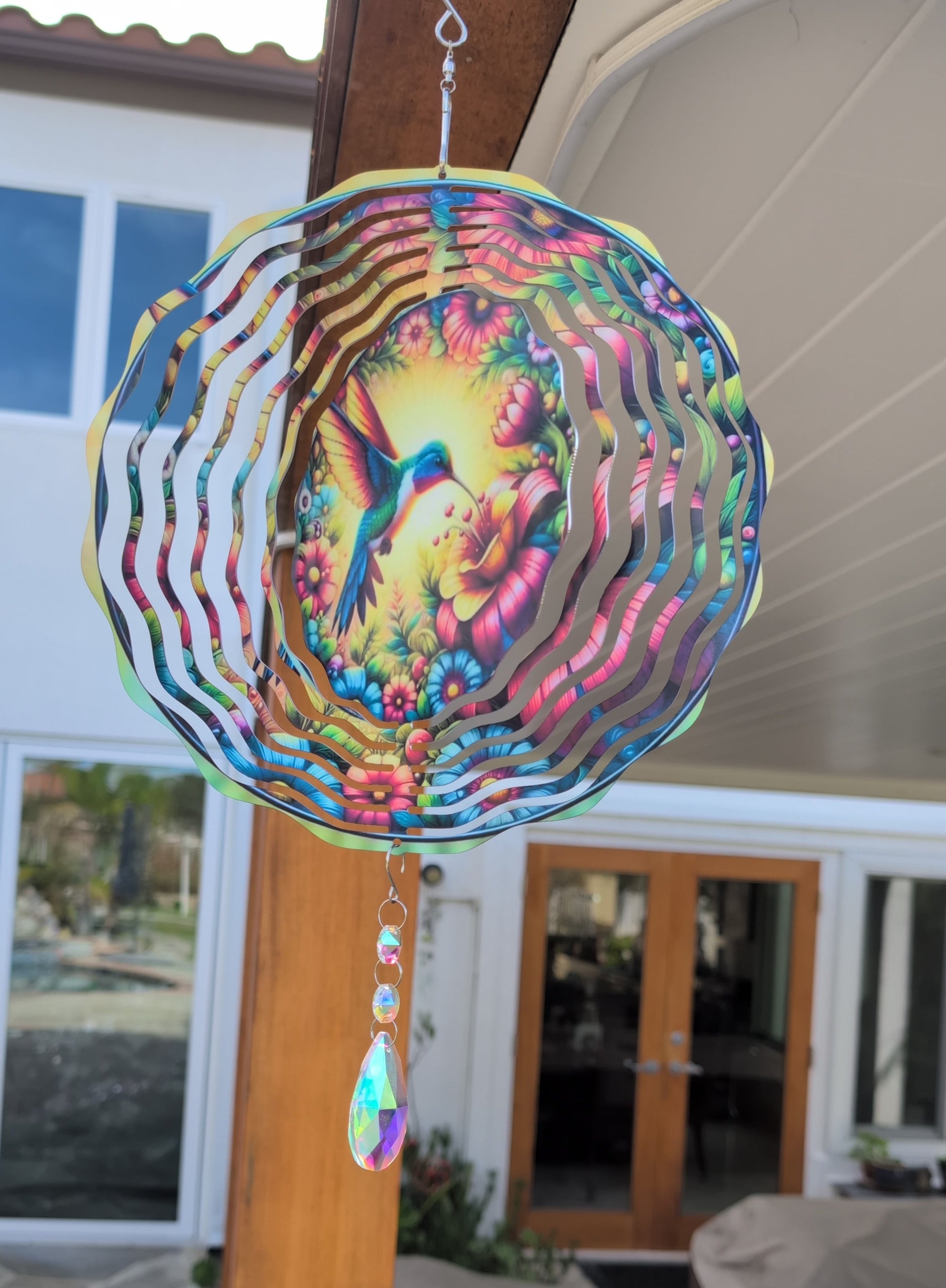 Metal hummingbird wind spinner for garden decor, outdoor hanging kinetic yard art.