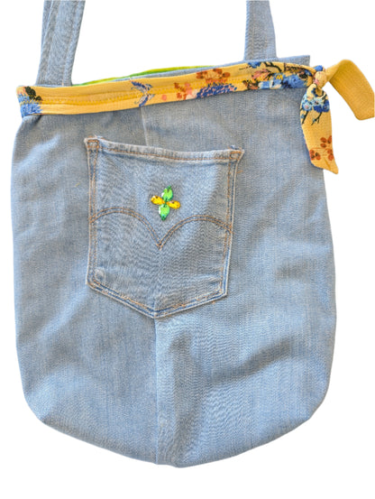 Showcase your eco-conscious style with this captivating Jean Bag featuring dazzling rhinestone accents, a charming yellow floral detail, and vibrant green-yellow striped lining. Perfectly sized at 10.5×11.5×2.5 inches with comfortable 26-inch straps, this versatile accessory effortlessly carries all your daily essentials—from your phone and wallet to sunglasses and more. Crafted thoughtfully from a blend of refurbished and new materials, this bag lets you make a fashion statement while reducing environmenta