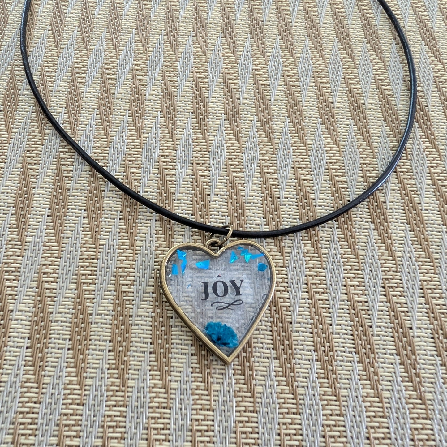 This stunning necklace features an 18 inch black leather cord with a resin and flowers bronze heart pendant. The extension chain allows for a customizable fit. Weighing only 0.2 oz, it's a lightweight and stylish addition to any outfit. Show your love and creativity with this unique necklace.