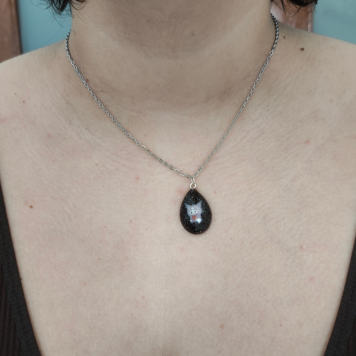 This stunning necklace features a 16.5 inch stainless steel link cable chain with a charming resin Kuromi character pendant. Crafted with quality materials, this necklace is both durable and stylish. Upgrade your accessory game with this unique and eye-catching piece.