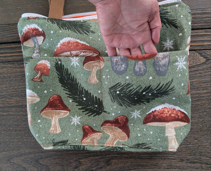 Crafted from durable cotton, this 13x9" bag features a sturdy 3.5" flat bottom and comfortable 26-inch straps for easy carrying. The vibrant orange lining adds a pop of color inside, while two outer pockets and one inner pocket keep your essentials organized. 