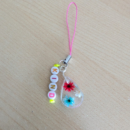 Spice up your phone with this charming resin charm, adorned with real dried flowers and beads. The 3.75 inch length adds a touch of flair to any device. (It's like a bouquet, but for your phone!)

Phone charm - Resin charm with dried flowers and beads