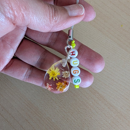 Spice up your phone with this charming resin charm, adorned with real dried flowers and beads. The 3.75 inch length adds a touch of flair to any device. (It's like a bouquet, but for your phone!)