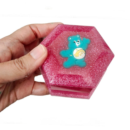 Add a touch of whimsy to your jewelry collection with our Knickknack Resin Hexagon Jewelry Box. The character lid adds a playful element to your storage, while the resin material ensures durability and protection for your precious pieces. Keep your jewelry safe and organized with this unique and charming box.