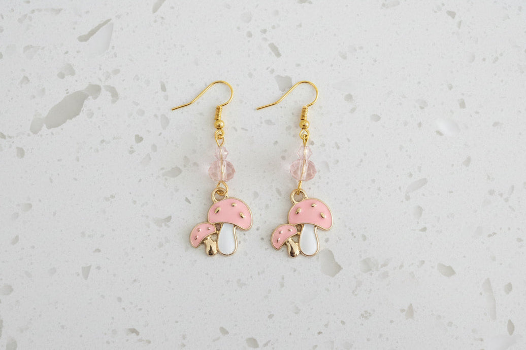 Enchanting mushroom earrings featuring delicate crystal beads nestled on lustrous gold plated hooks. Each earring measures approximately 2 inches, striking the perfect balance between statement-making and wearable elegance. At just 0.15 oz per pair, these lightweight beauties won't weigh you down, making them ideal for all-day wear. The shimmering gold plating catches the light beautifully, while the crystal accents add a touch of sparkle and sophistication. 