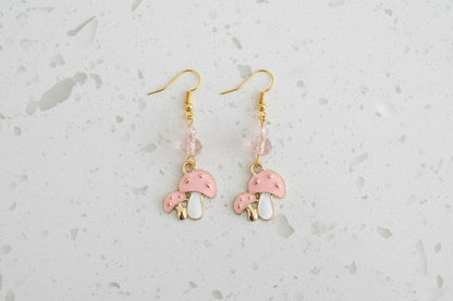 Enchanting mushroom earrings featuring delicate crystal beads nestled on lustrous gold plated hooks. Each earring measures approximately 2 inches, striking the perfect balance between statement-making and wearable elegance. At just 0.15 oz per pair, these lightweight beauties won't weigh you down, making them ideal for all-day wear. The shimmering gold plating catches the light beautifully, while the crystal accents add a touch of sparkle and sophistication. 