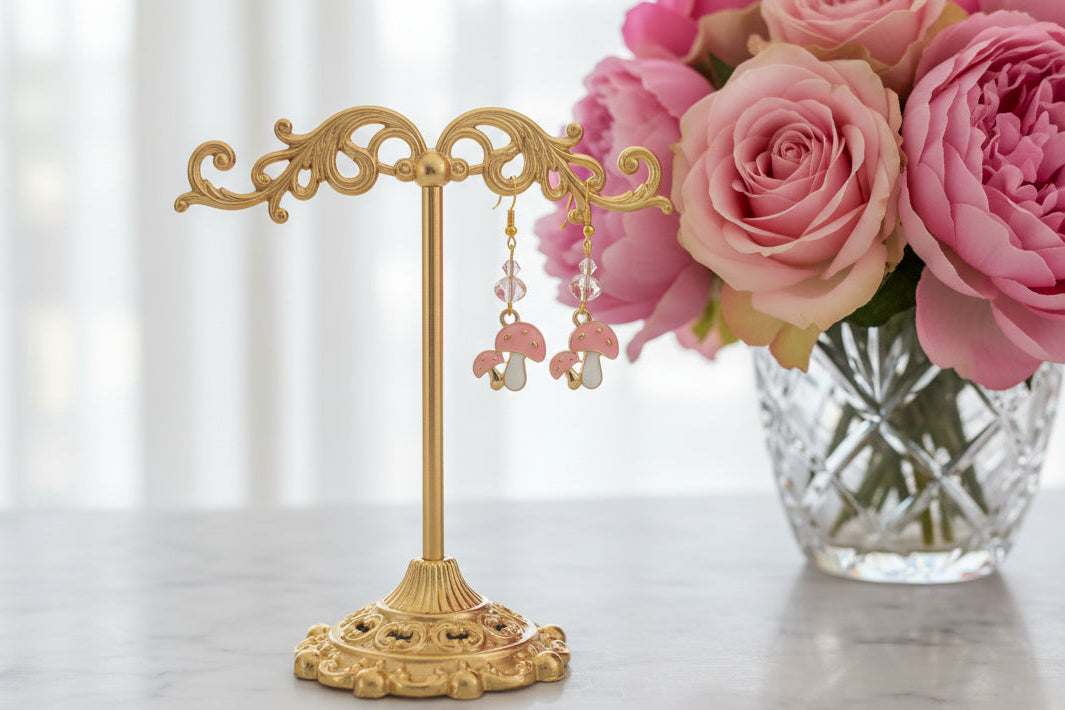 Enchanting mushroom earrings featuring delicate crystal beads nestled on lustrous gold plated hooks. Each earring measures approximately 2 inches, striking the perfect balance between statement-making and wearable elegance. At just 0.15 oz per pair, these lightweight beauties won't weigh you down, making them ideal for all-day wear. The shimmering gold plating catches the light beautifully, while the crystal accents add a touch of sparkle and sophistication. 