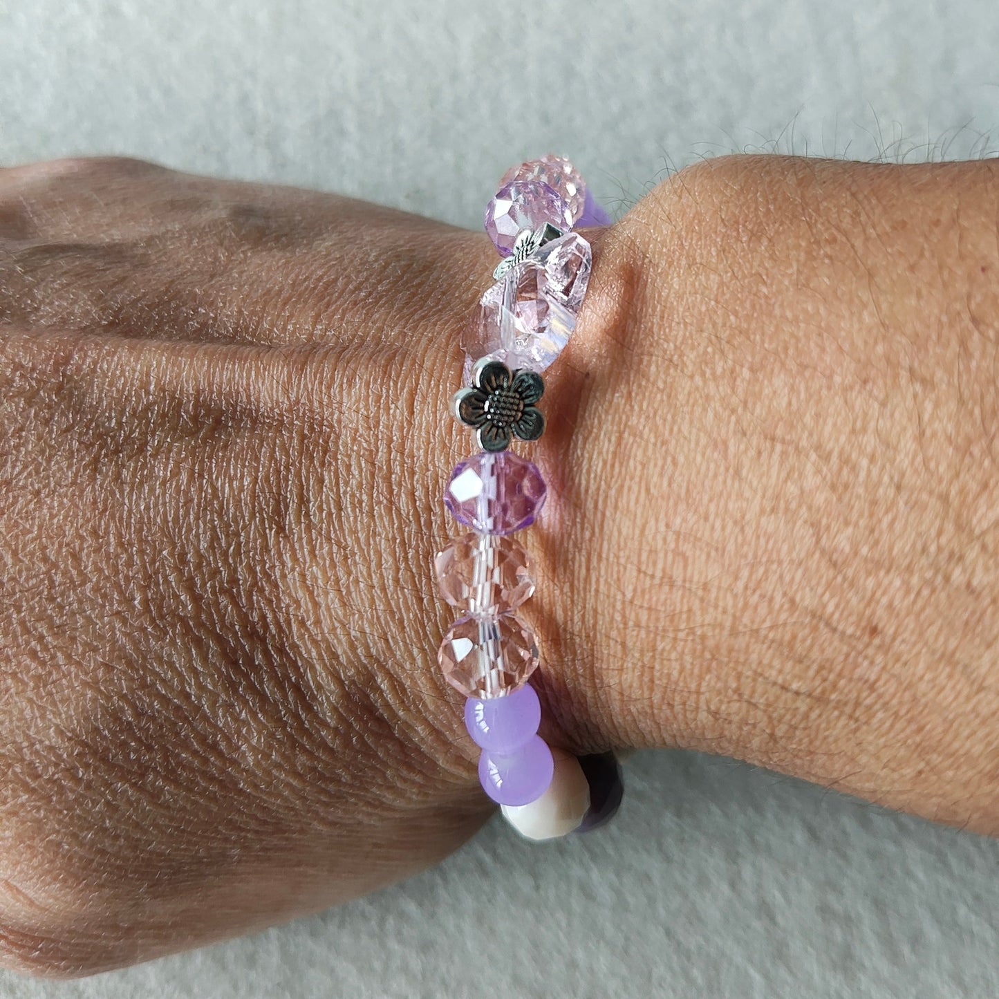 Add a touch of whimsy to your outfit with this elastic crystal butterfly bracelet. Featuring pink and purple crystal and glass beads, along with metal flower spacers, it's sure to catch eyes. Weighing only 0.40 oz, it's lightweight and comfortable to wear.

Bracelet - Elastic Crystal butterfly bead with pink and purple beads and flower metal spacer beads

Crystal butterfly bead and 8mm pink and purple crystal beads, Glass 8mm pink and purple tear drop beads, Glass 6 mm green beads, Metal flower spacer beads