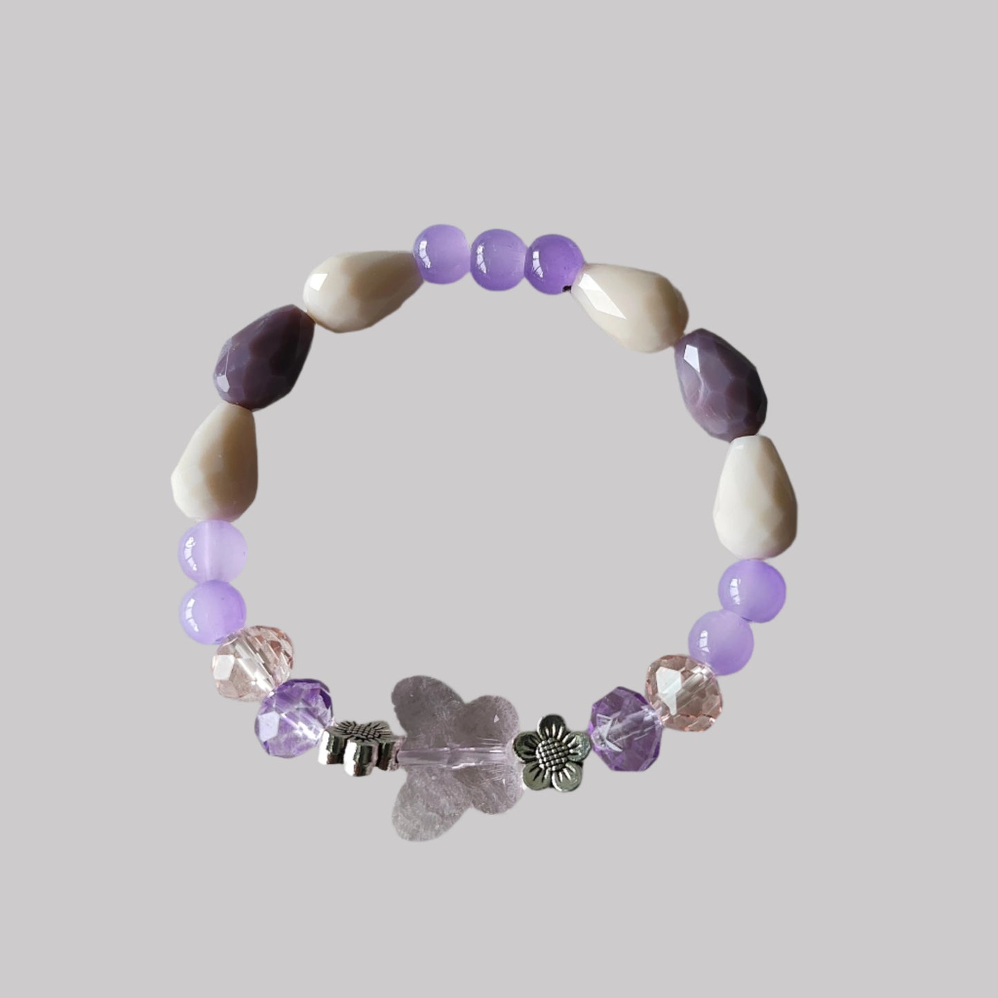 Add a touch of whimsy to your outfit with this elastic crystal butterfly bracelet. Featuring pink and purple crystal and glass beads, along with metal flower spacers, it's sure to catch eyes. Weighing only 0.40 oz, it's lightweight and comfortable to wear.

Bracelet - Elastic Crystal butterfly bead with pink and purple beads and flower metal spacer beads

Crystal butterfly bead and 8mm pink and purple crystal beads, Glass 8mm pink and purple tear drop beads, Glass 6 mm green beads, Metal flower spacer beads