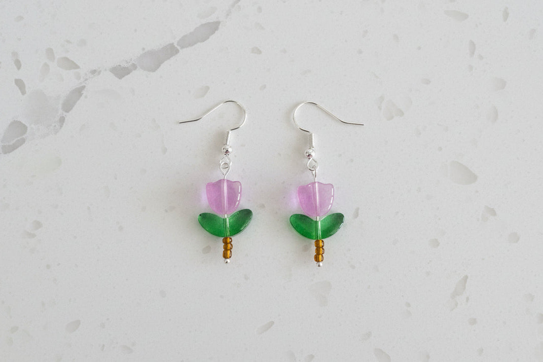 Delicate crystal and seed beads form an enchanting flower design, suspended from hypoallergenic 925 sterling silver hooks. These lightweight earrings measure just 1.5 inches, making them perfect for everyday elegance or layering with other pieces. At only 0.1 oz, they're comfortable enough to wear all day without fatigue. The shimmering bead work catches light beautifully, adding a touch of sparkle and sophistication to any outfit. Ideal for those who appreciate handcrafted jewelry with timeless appeal.