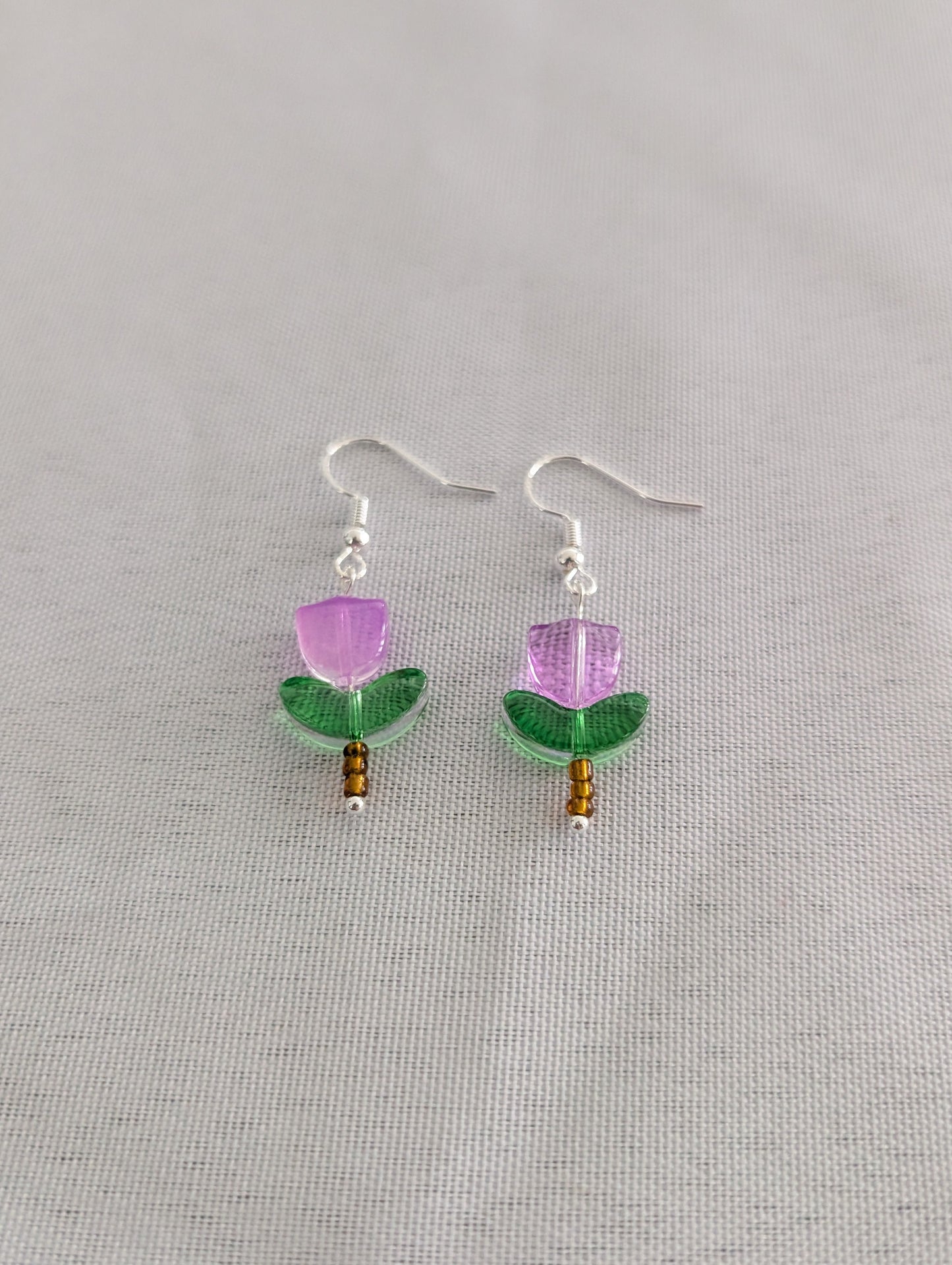 Delicate crystal and seed beads form an enchanting flower design, suspended from hypoallergenic 925 sterling silver hooks. These lightweight earrings measure just 1.5 inches, making them perfect for everyday elegance or layering with other pieces. At only 0.1 oz, they're comfortable enough to wear all day without fatigue. The shimmering bead work catches light beautifully, adding a touch of sparkle and sophistication to any outfit. Ideal for those who appreciate handcrafted jewelry with timeless appeal.