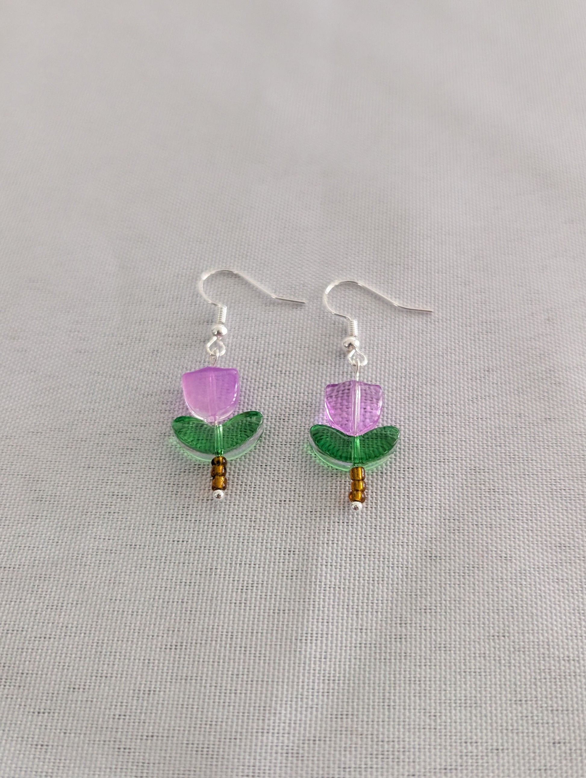 Delicate crystal and seed beads form an enchanting flower design, suspended from hypoallergenic 925 sterling silver hooks. These lightweight earrings measure just 1.5 inches, making them perfect for everyday elegance or layering with other pieces. At only 0.1 oz, they're comfortable enough to wear all day without fatigue. The shimmering bead work catches light beautifully, adding a touch of sparkle and sophistication to any outfit. Ideal for those who appreciate handcrafted jewelry with timeless appeal.