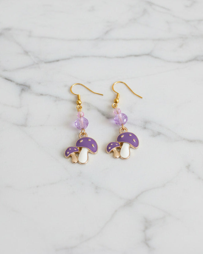 Enchanting mushroom earrings featuring delicate crystal beads nestled on lustrous gold plated hooks. Each earring measures approximately 2 inches, striking the perfect balance between statement-making and wearable elegance. At just 0.15 oz per pair, these lightweight beauties won't weigh you down, making them ideal for all-day wear. The shimmering gold plating catches the light beautifully, while the crystal accents add a touch of sparkle and sophistication. 