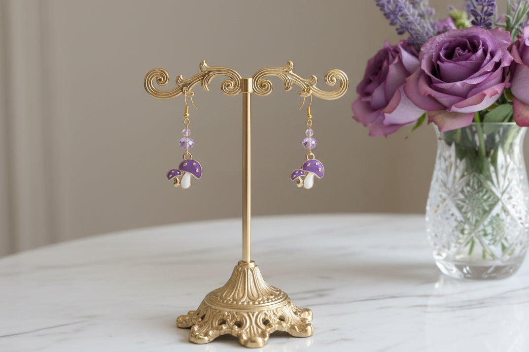 Enchanting mushroom earrings featuring delicate crystal beads nestled on lustrous gold plated hooks. Each earring measures approximately 2 inches, striking the perfect balance between statement-making and wearable elegance. At just 0.15 oz per pair, these lightweight beauties won't weigh you down, making them ideal for all-day wear. The shimmering gold plating catches the light beautifully, while the crystal accents add a touch of sparkle and sophistication. 