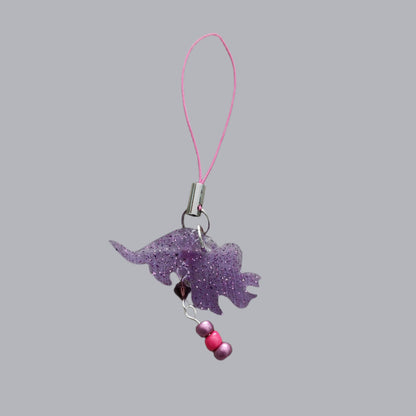 Add some prehistoric charm to your phone with our Triceratops resin dinosaur charm, adorned with colorful beads. Stand out from the herd and protect your phone in style. (No need to be a fossil to appreciate this cute accessory!)