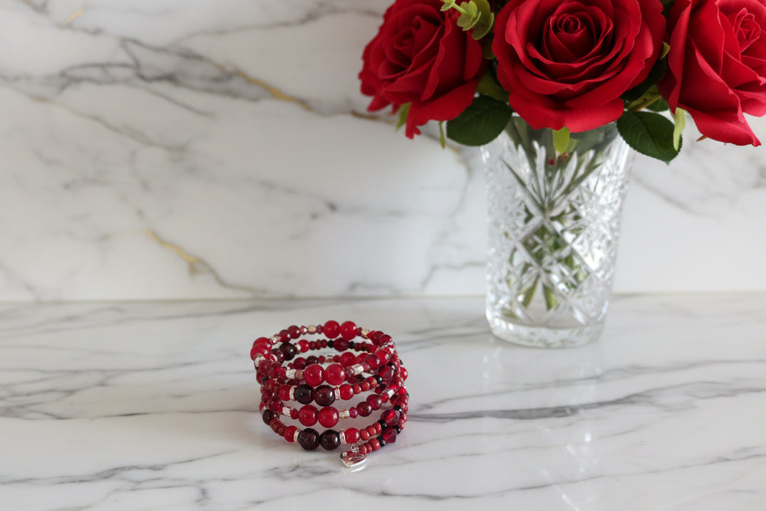 Elevate your everyday style with this stunning red memory wire bracelet, designed to make a lasting impression. Featuring a captivating mix of 8mm, 6mm, and 4mm red glass and crystal beads that catch the light beautifully, this piece combines elegance with versatility. Delicate gold spacer beads and vibrant red seed beads add intricate detail, while a charming silver heart pendant serves as the perfect finishing touch. The four-coil memory wire construction ensures a comfortable, secure fit that adapts to y