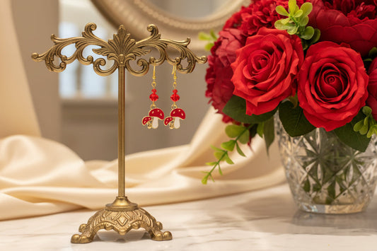 Enchanting mushroom earrings featuring delicate crystal beads nestled on lustrous gold plated hooks. Each earring measures approximately 2 inches, striking the perfect balance between statement-making and wearable elegance. At just 0.15 oz per pair, these lightweight beauties won't weigh you down, making them ideal for all-day wear. The shimmering gold plating catches the light beautifully, while the crystal accents add a touch of sparkle and sophistication. 