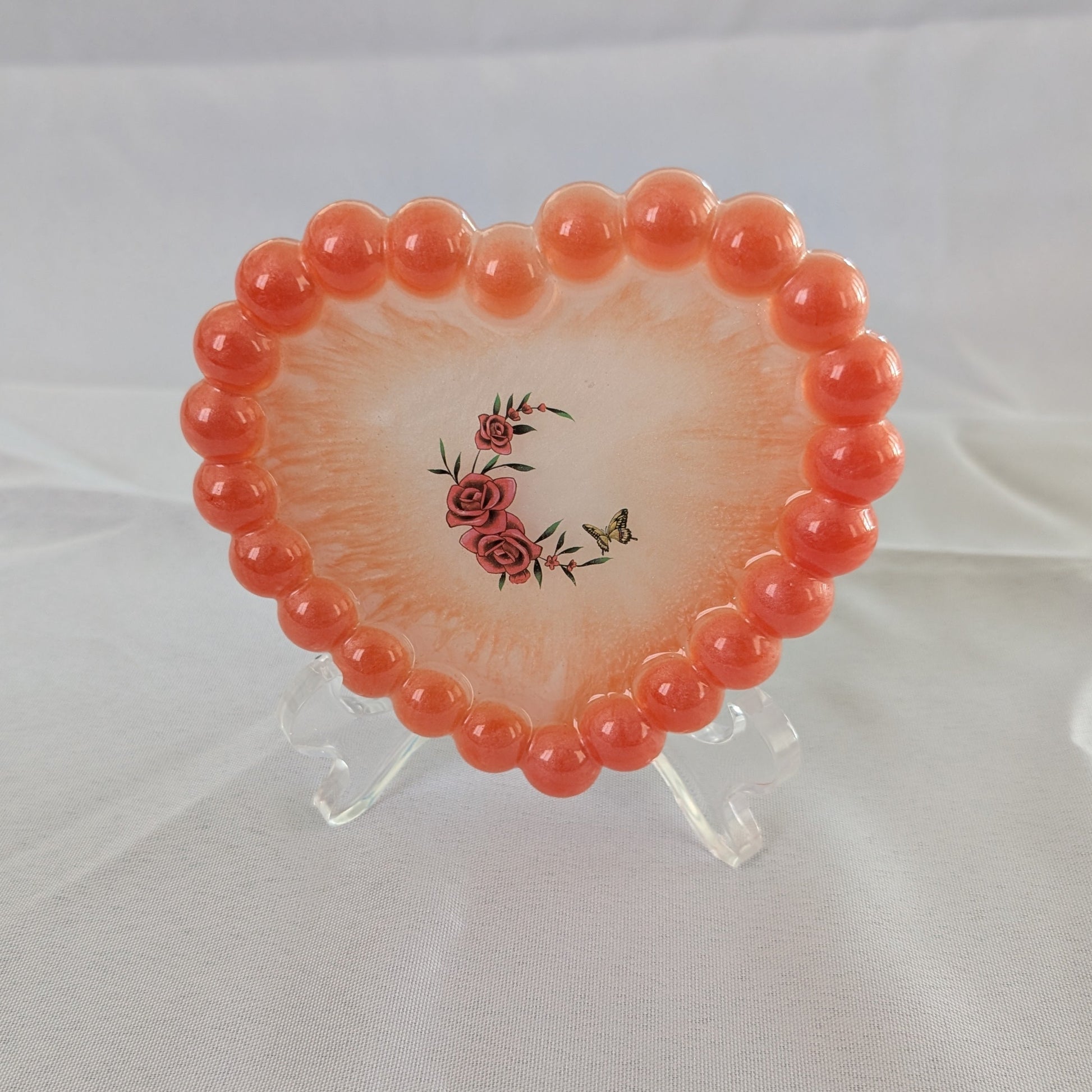 Elevate your space with our Resin Heart Trinket Tray. Formed into a heart shape, this tray is perfect for holding and displaying your small trinkets and treasures. Made of durable resin, it adds a touch of charm to any room while keeping your items organized and easily accessible.