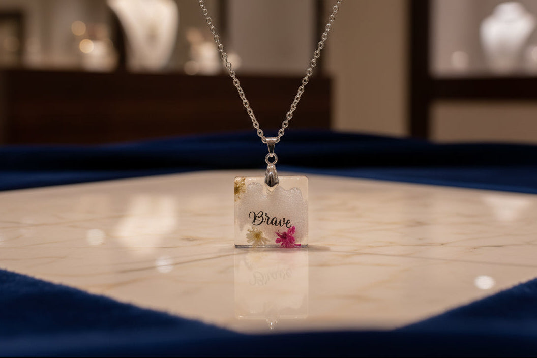 This stainless steel cable link chain necklace features a beautiful square pendant with real flowers embedded in resin. The necklace is 21 inches long, with an additional 2 inch extension chain. Make a statement with this one-of-a-kind piece!

Necklace - 21 inches stainless steel cable link chain with a resin with flowers square pendant