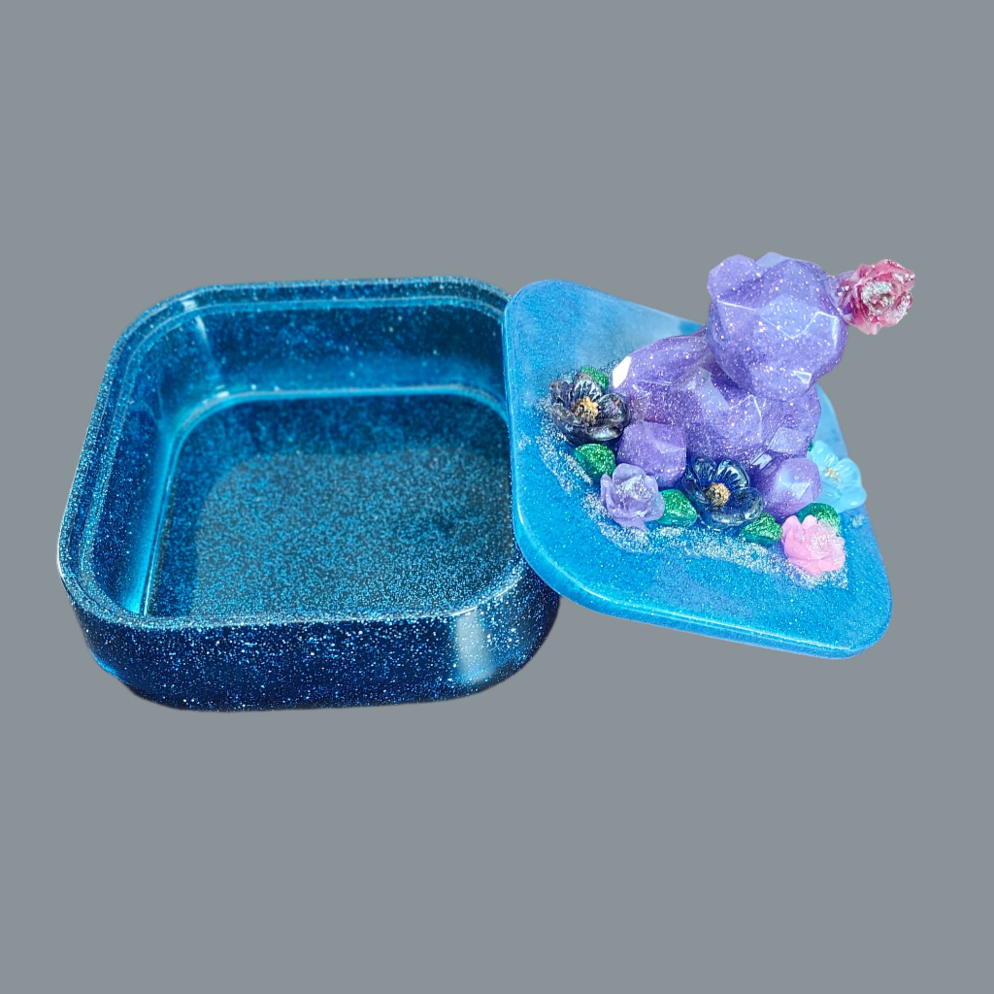 Elevate your jewelry storage with our Knickknack - Large resin square box! Featuring a charming bear and flowers lid, it adds a whimsical touch to any room. Boasting ample space for your precious items, it's the perfect blend of function and beauty. Upgrade to this stunning jewelry box today!