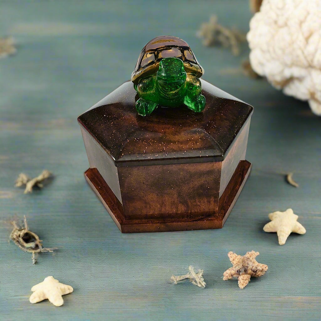 Add a playful touch to your home decor with this Knickknack! The resin hexagon trinket box features a turtle lid and is the perfect size for storing small treasures. With dimensions of 2.5 x 3 x 1 inches and weighing only 3.4 ounces, it's a quirky and lightweight addition to any room.