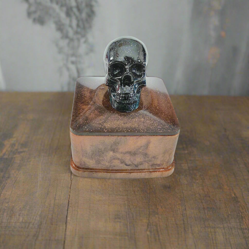 Say goodbye to boring trinket boxes and hello to this quirky Knickknack! Made of sturdy resin, it features a skull lid that adds a touch of spookiness to your decor. With dimensions of 3 x 3 x 3.5 inches and weighing only 5 oz, it's perfect for storing your knickknacks in style.

Resin square jewelry/trinket box with skull lid
