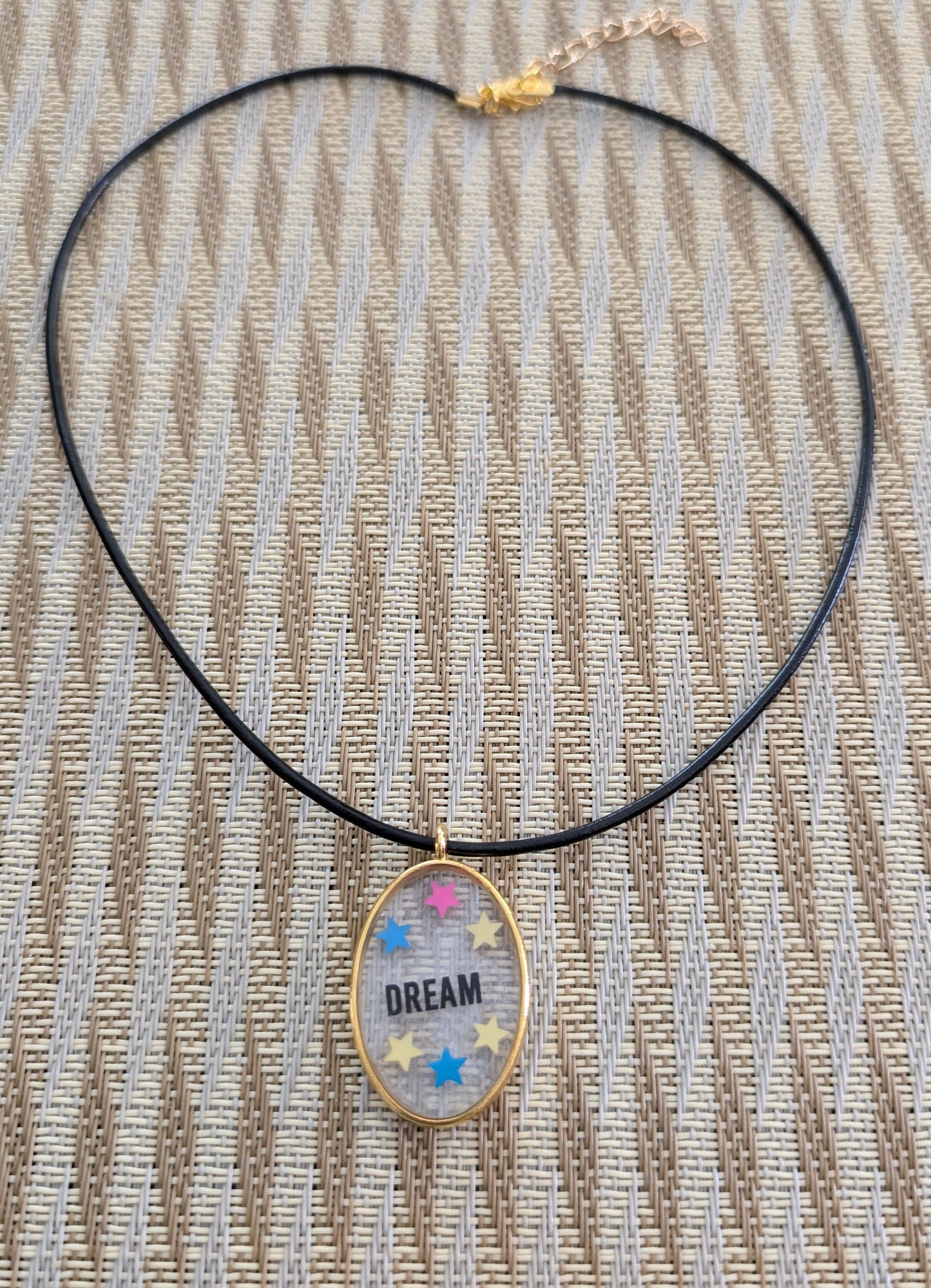 Indulge in the dreamy beauty of our 18 inch resin and stars gold oval pendant necklace. The stunning design is complemented by a 2mm black leather cord and adjustable extension chain. Weighing only 0.2 oz, it's lightweight and comfortable to wear. Elevate your style with this unique and charming accessory.
