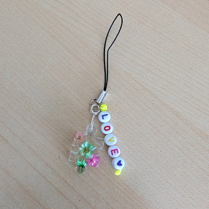 Spice up your phone with this charming resin charm, adorned with real dried flowers and beads. The 3.75 inch length adds a touch of flair to any device. (It's like a bouquet, but for your phone!)

Phone charm - Resin charm with dried flowers and beads