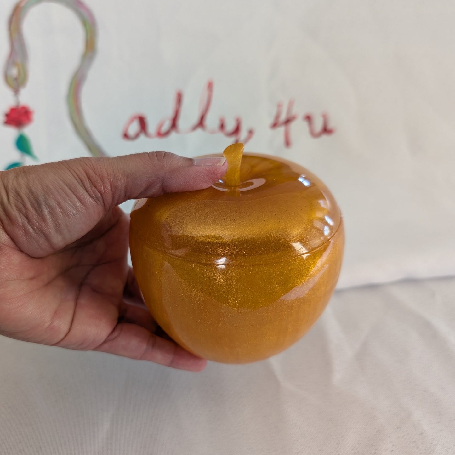 hand crafted with epoxy resin..

Epoxy resin is typically smooth, rigid, and non-porous, similar to a hard plastic or glass.

Knickknack - Resin apple trinket with lid