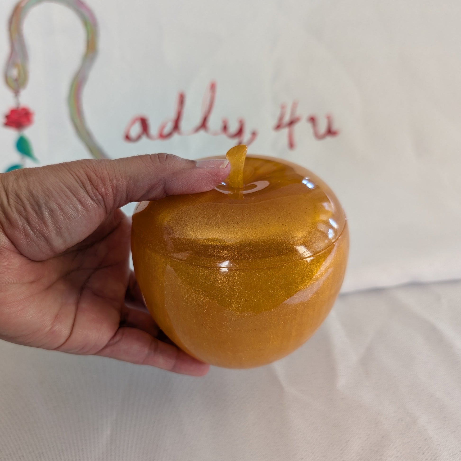 hand crafted with epoxy resin..

Epoxy resin is typically smooth, rigid, and non-porous, similar to a hard plastic or glass.

Knickknack - Resin apple trinket with lid