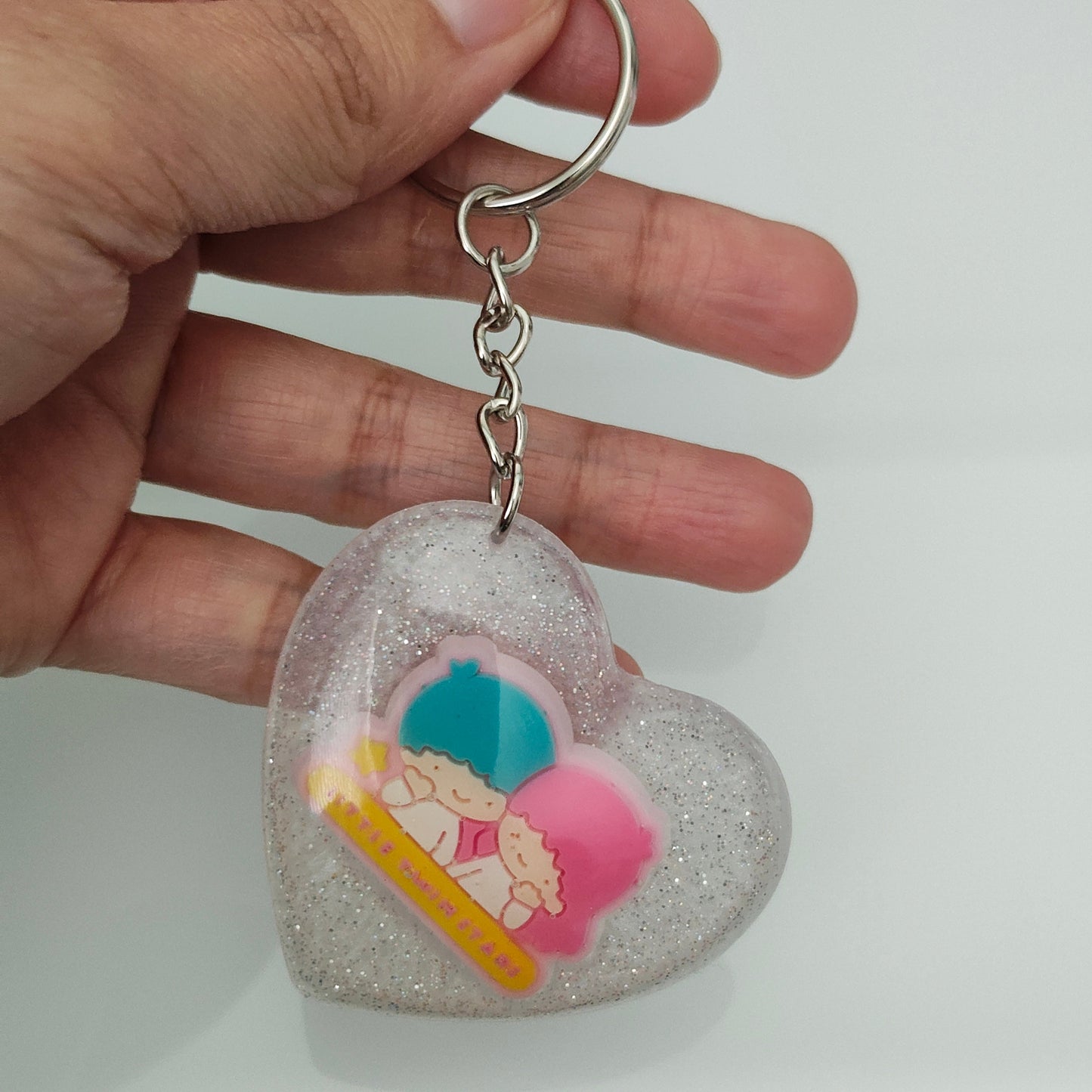 This 3D resin Kiki & Lala heart keychain is a must-have accessory for any fan of the beloved characters. The intricate design and vibrant colors are sure to catch the eyes and hearts of all who see it. Carry your keys with style and show off your love for Kiki & Lala with this charming keychain!