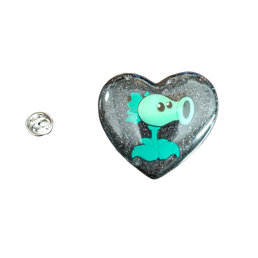 Transform any outfit into a statement piece with our 3D Peashooter resin pin! Featuring a silver butterfly clutch, this pin adds the perfect touch of whimsy and personality. Complete your look with this unique and eye-catching accessory.