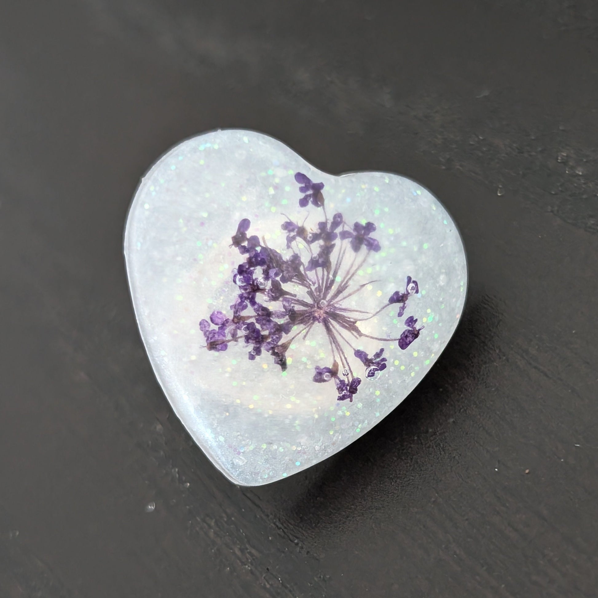 Add a touch of nature to your outfit with our Pin - 3D dried flower resin pin. The intricate design and 3D effect will surely catch everyone's eye. With the sturdy silver butterfly clutch, your pin will stay securely in place. Elevate your style with this unique and beautiful accessory.