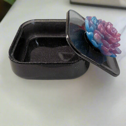 Elevate your jewelry collection with this stunning Knickknack jewelry box. Featuring a flower lid and made of durable resin, this box measures 5 x 5 inches and has a depth of 1.5 inches, making it perfect for large pieces. Weighing only 14 oz, it's also lightweight and easy to transport. Transform your dressing table and protect your precious pieces with this beautiful box.