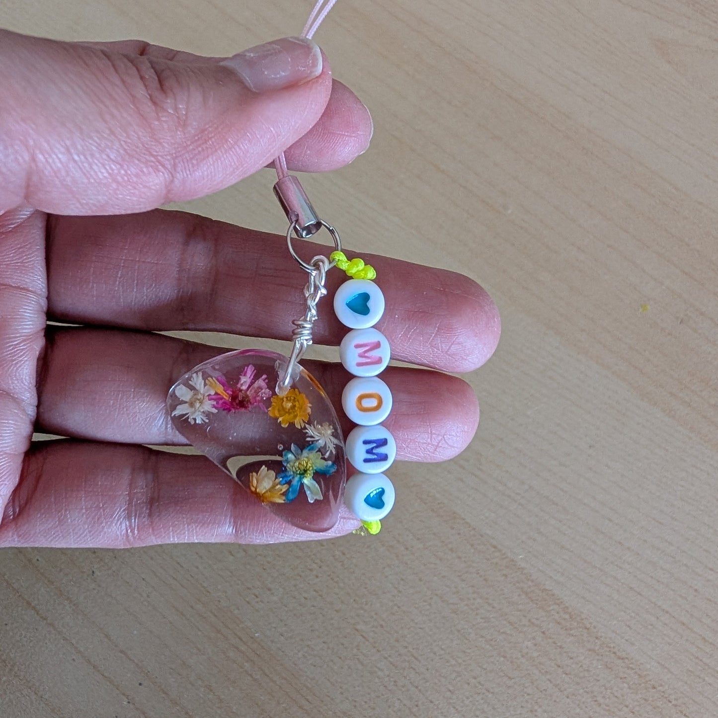 Spice up your phone with this charming resin charm, adorned with real dried flowers and beads. The 3.75 inch length adds a touch of flair to any device. (It's like a bouquet, but for your phone!)

Phone charm - Resin charm with dried flowers and beads