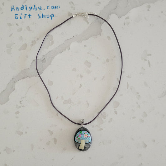 Necklace with a pendant featuring a mushroom design on a textured surface.