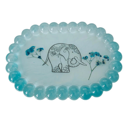 Organize and display your trinkets in style with our Resin Oval jewelry/Trinket Tray. Made from durable resin, this tray adds a touch of elegance to any space. Its unique oval shape and smooth finish make it perfect for storing your small items. Keep your trinkets safe and organized with this beautiful tray!