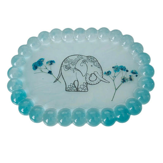Organize and display your trinkets in style with our Resin Oval jewelry/Trinket Tray. Made from durable resin, this tray adds a touch of elegance to any space. Its unique oval shape and smooth finish make it perfect for storing your small items. Keep your trinkets safe and organized with this beautiful tray!